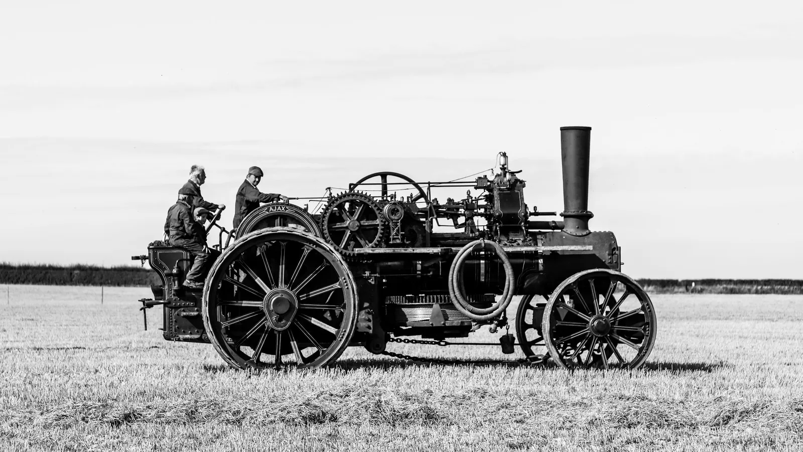 An old steam traction engine in a field, in black and white