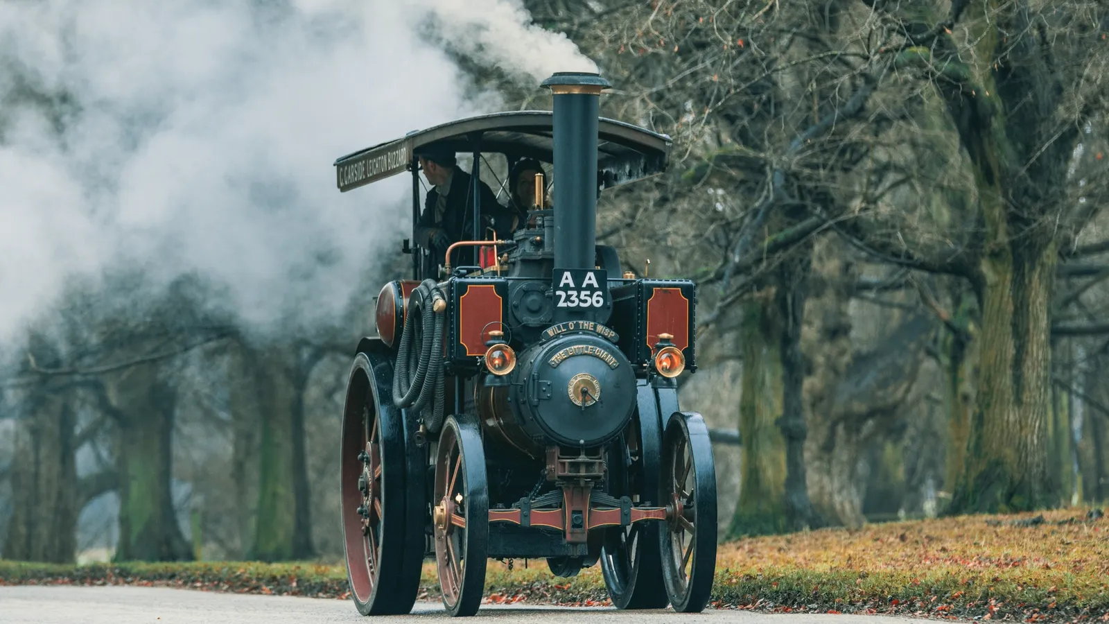 An old steam traction engine puffing smoke on a road