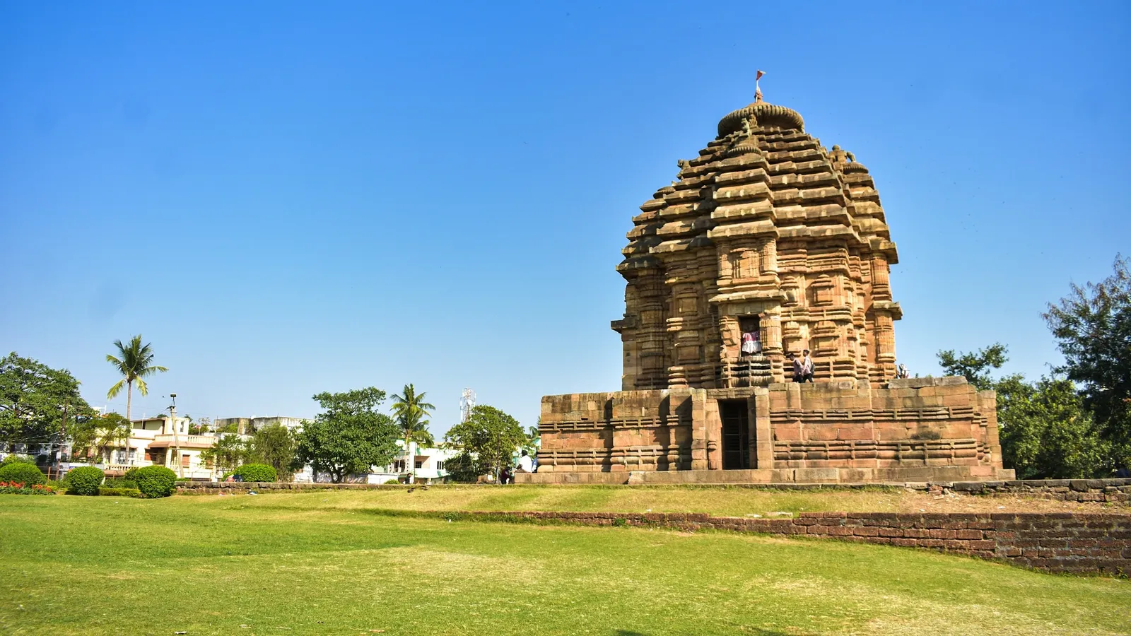 An old stone temple in Bhubaneswar under a blue sky