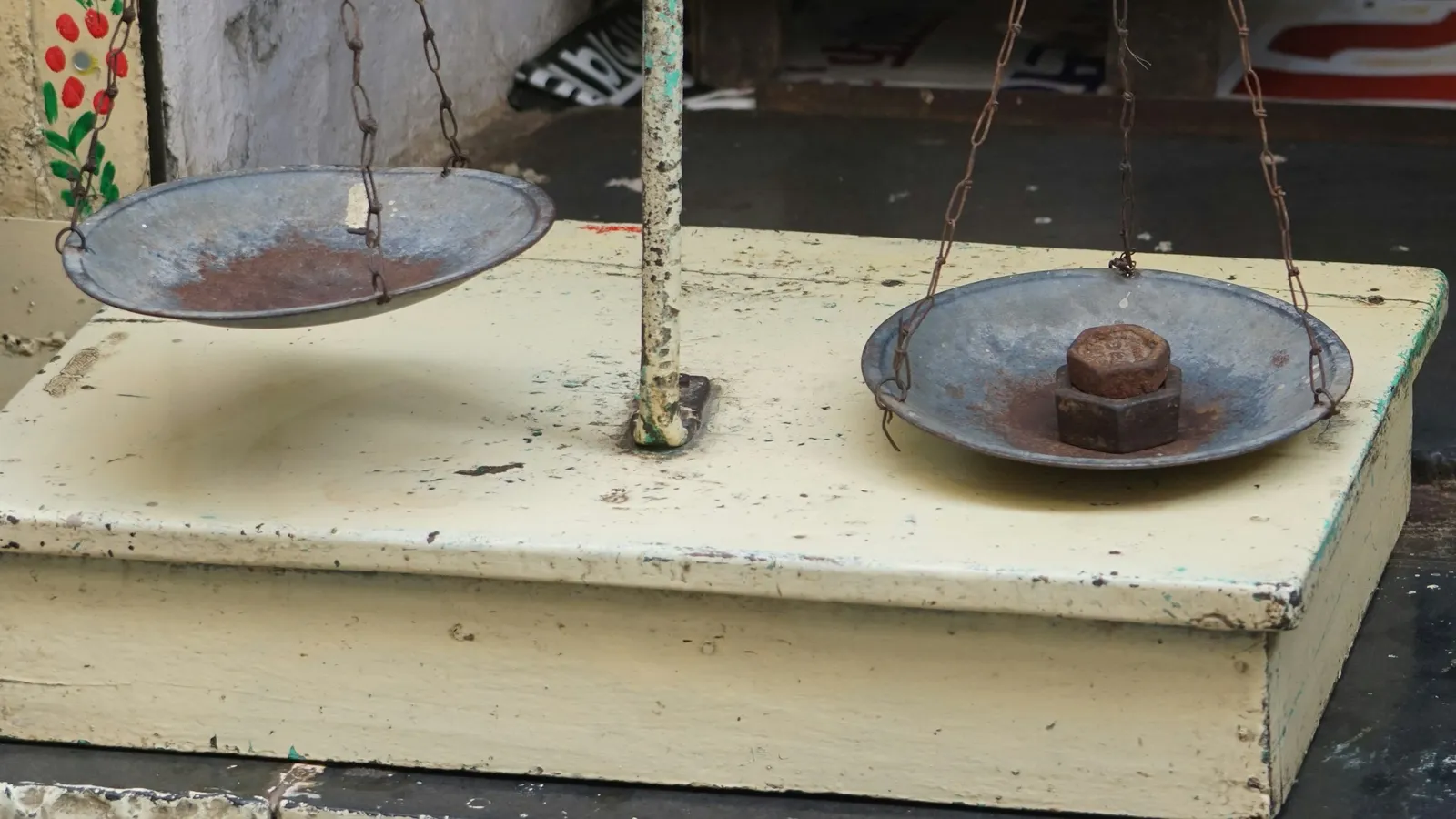 An old two-pan balance scale on a wooden base