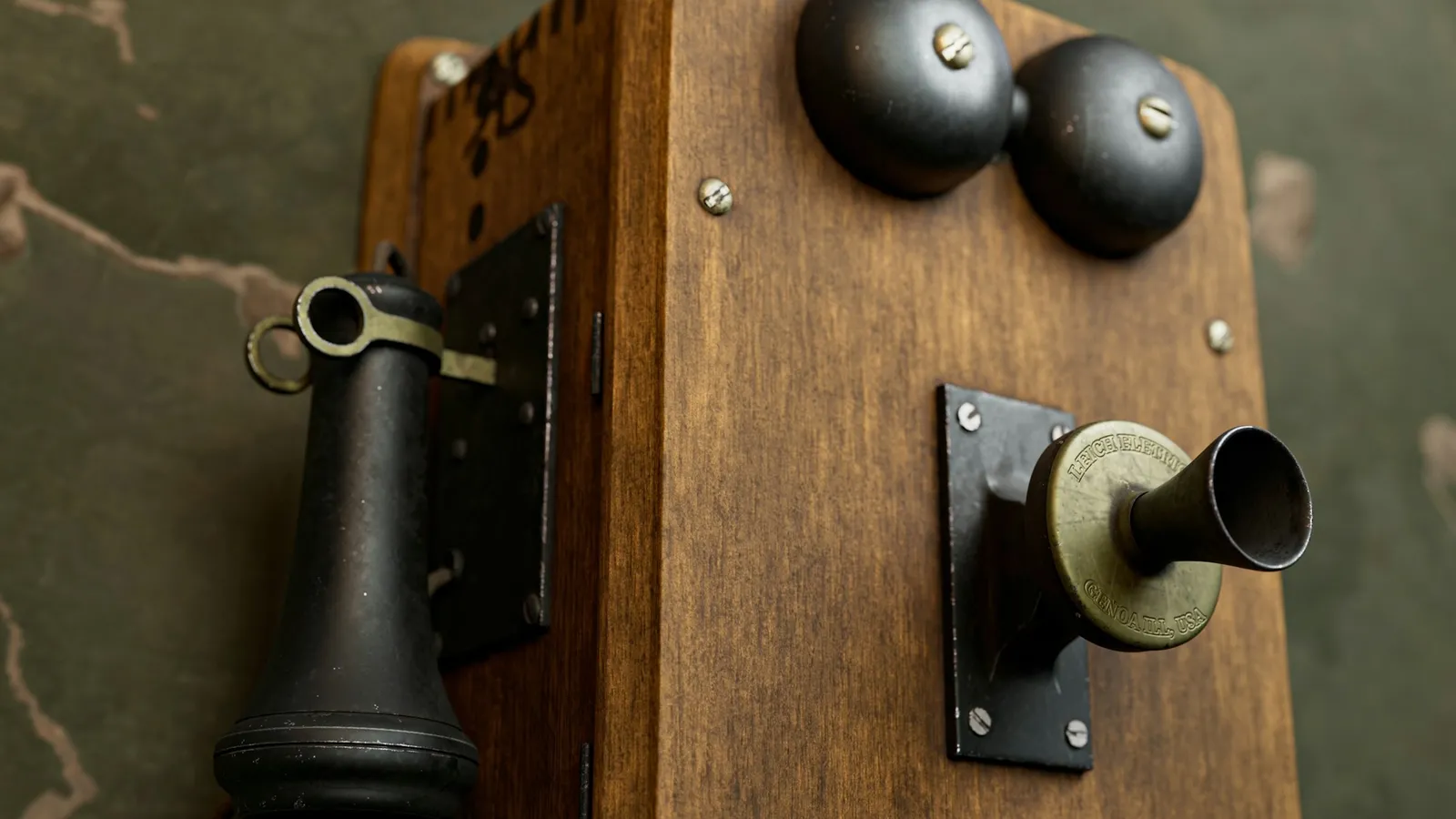 An old wooden wall telephone with brass bells