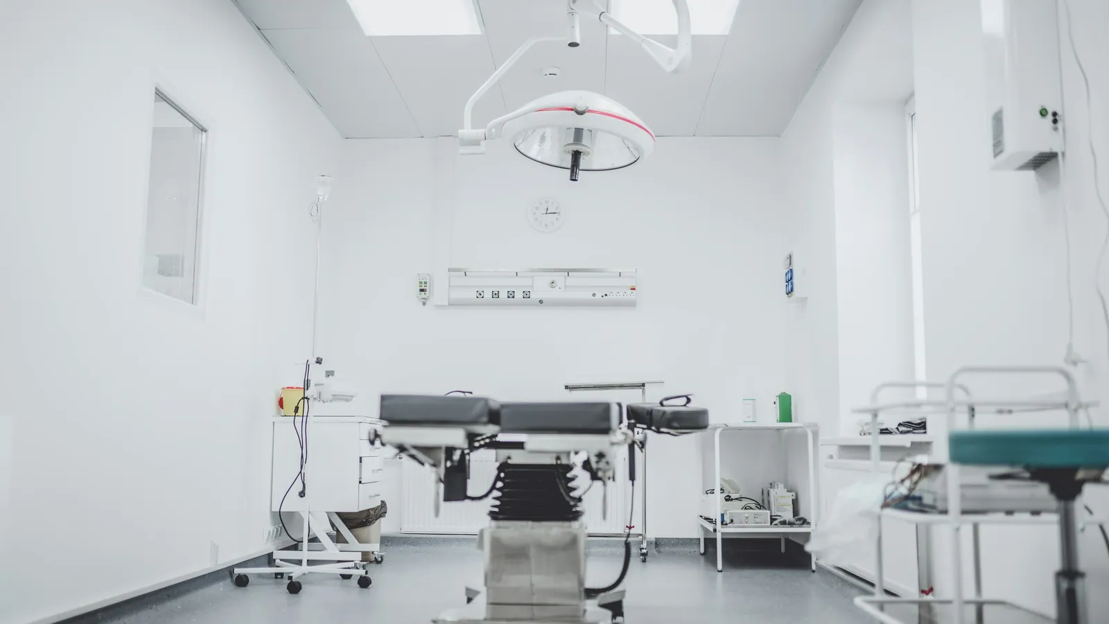 An operating room with a surgical table, lights and equipment