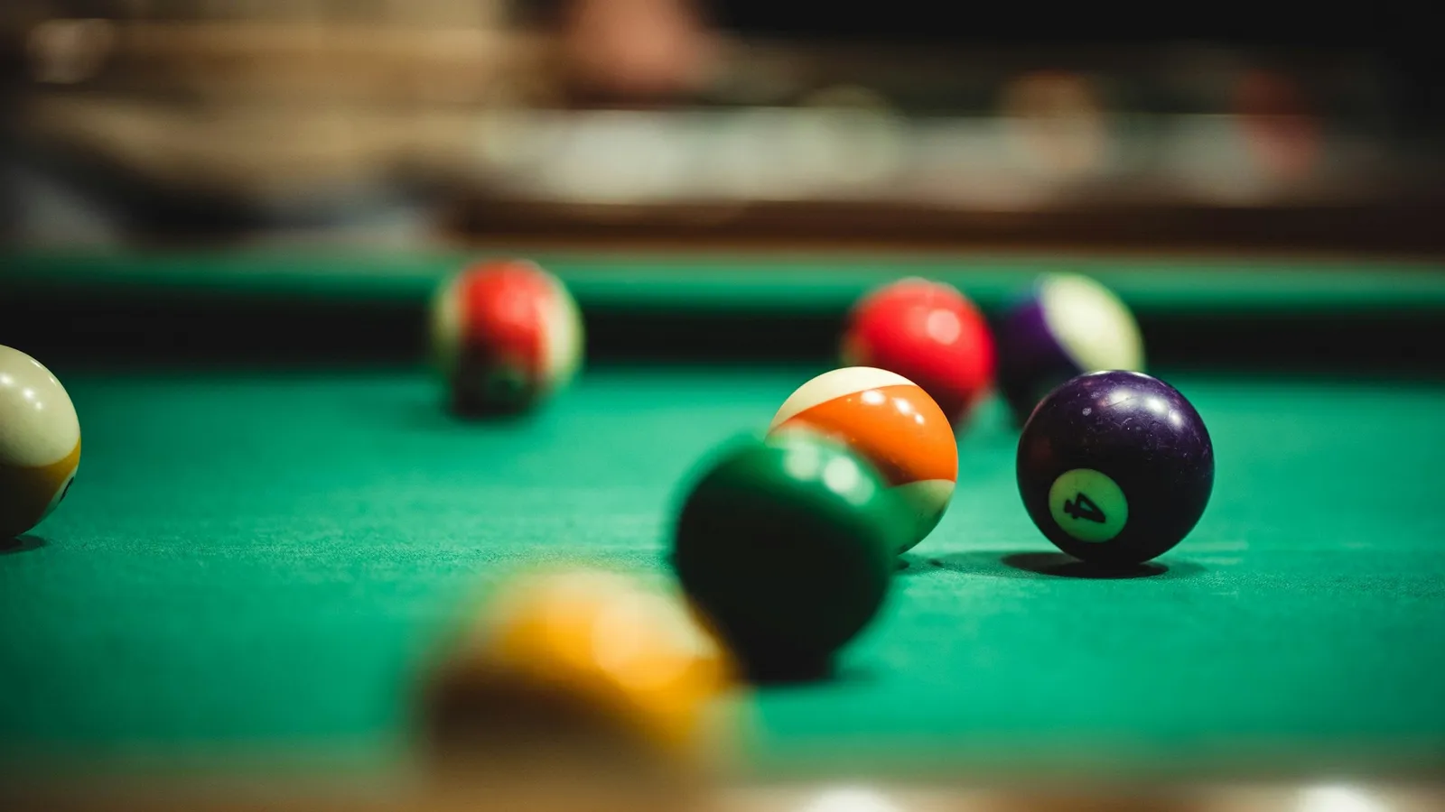 Billiard balls scattered across a green pool table