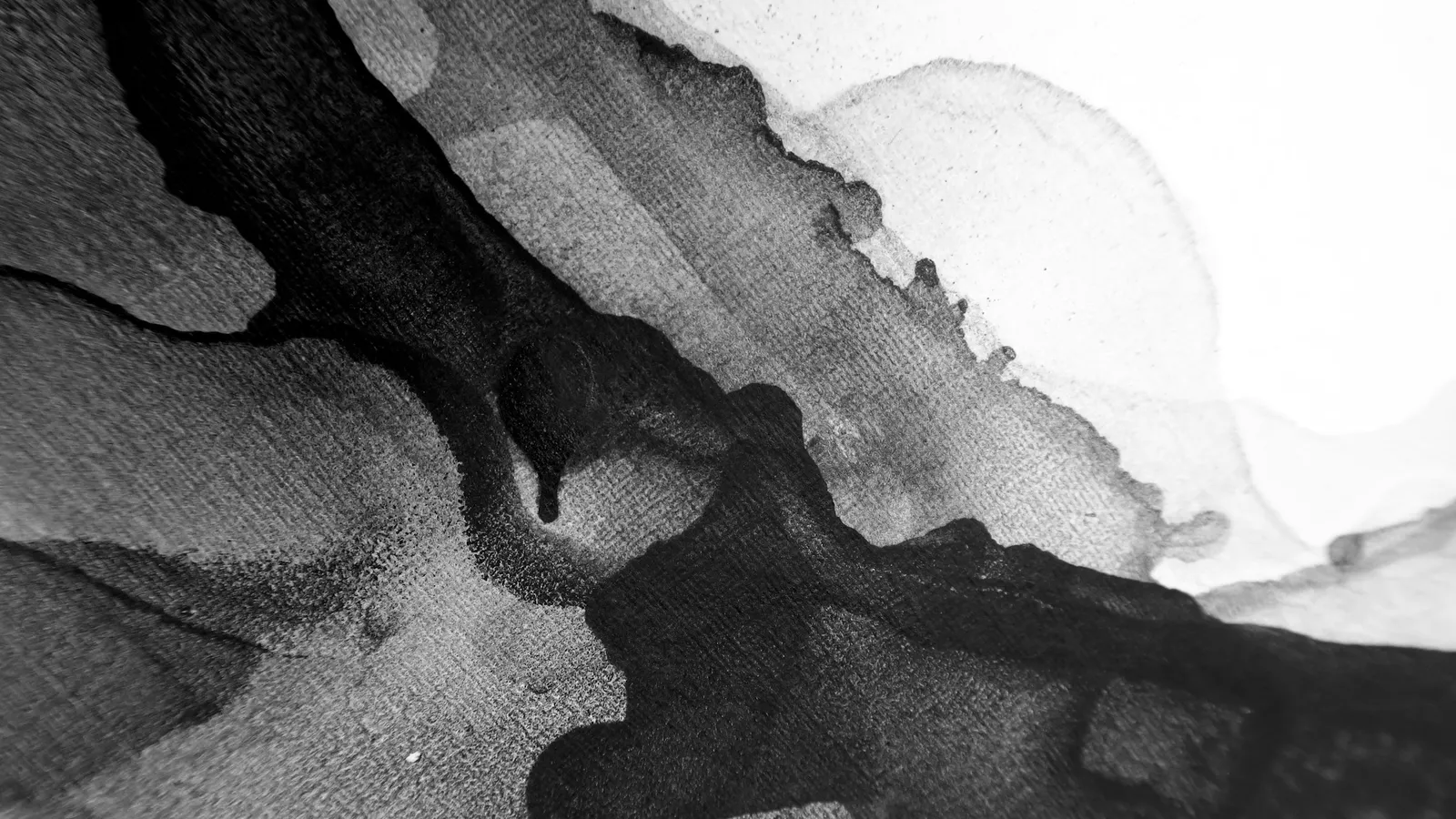 Black ink spreading in cloud-like patterns through water