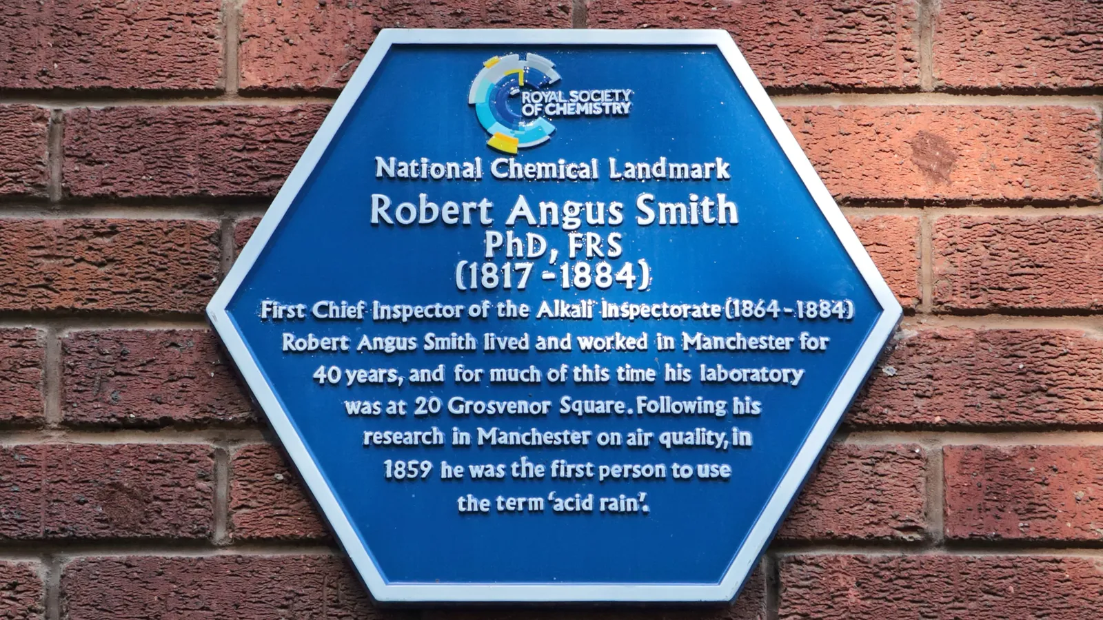 Blue hexagonal Royal Society of Chemistry plaque for Robert Angus Smith on brick wall
