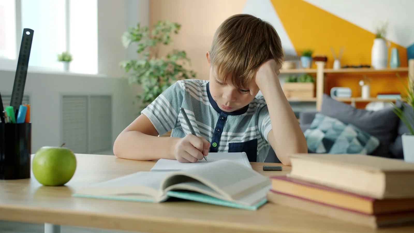 Boy working through a textbook at his desk