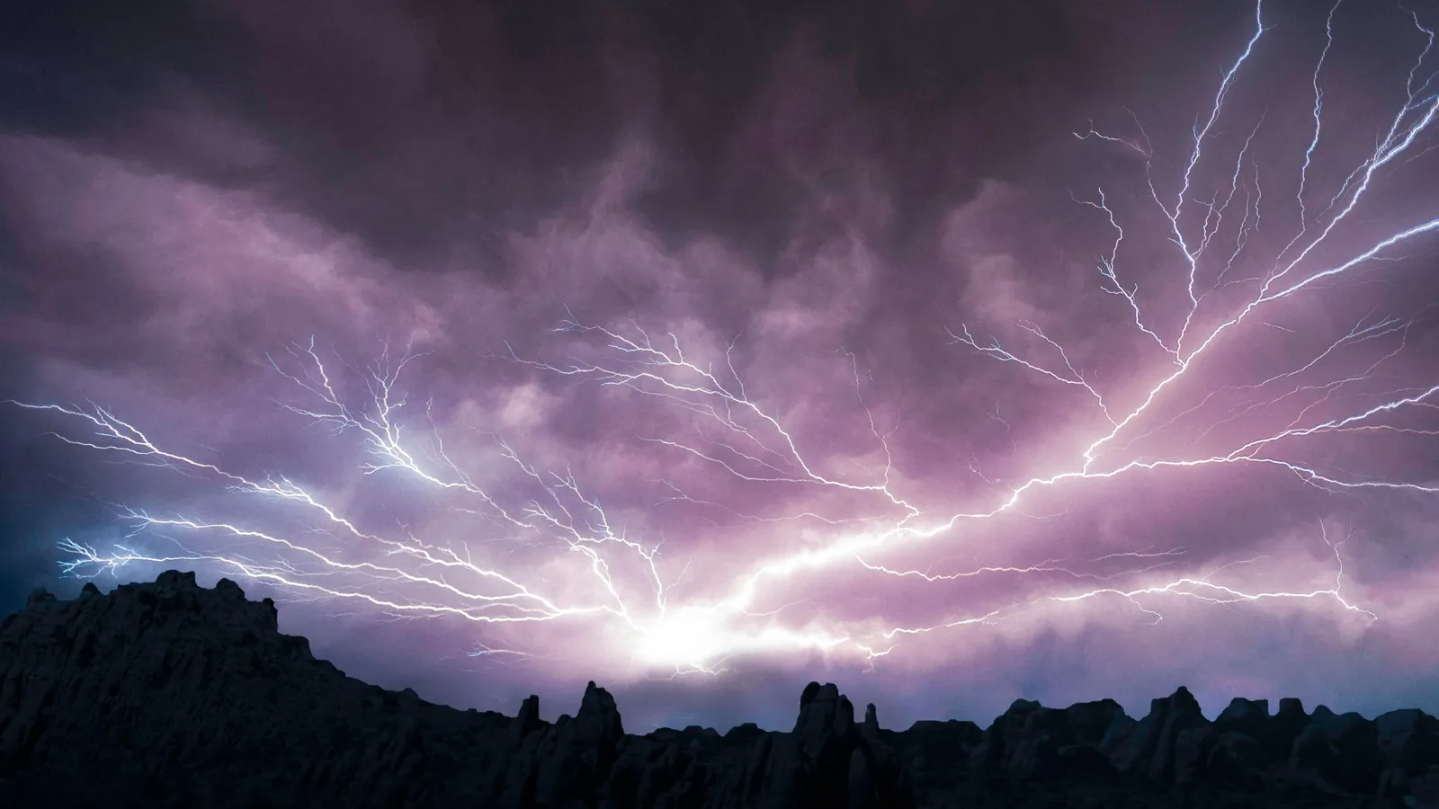Branching lightning across a purple night sky