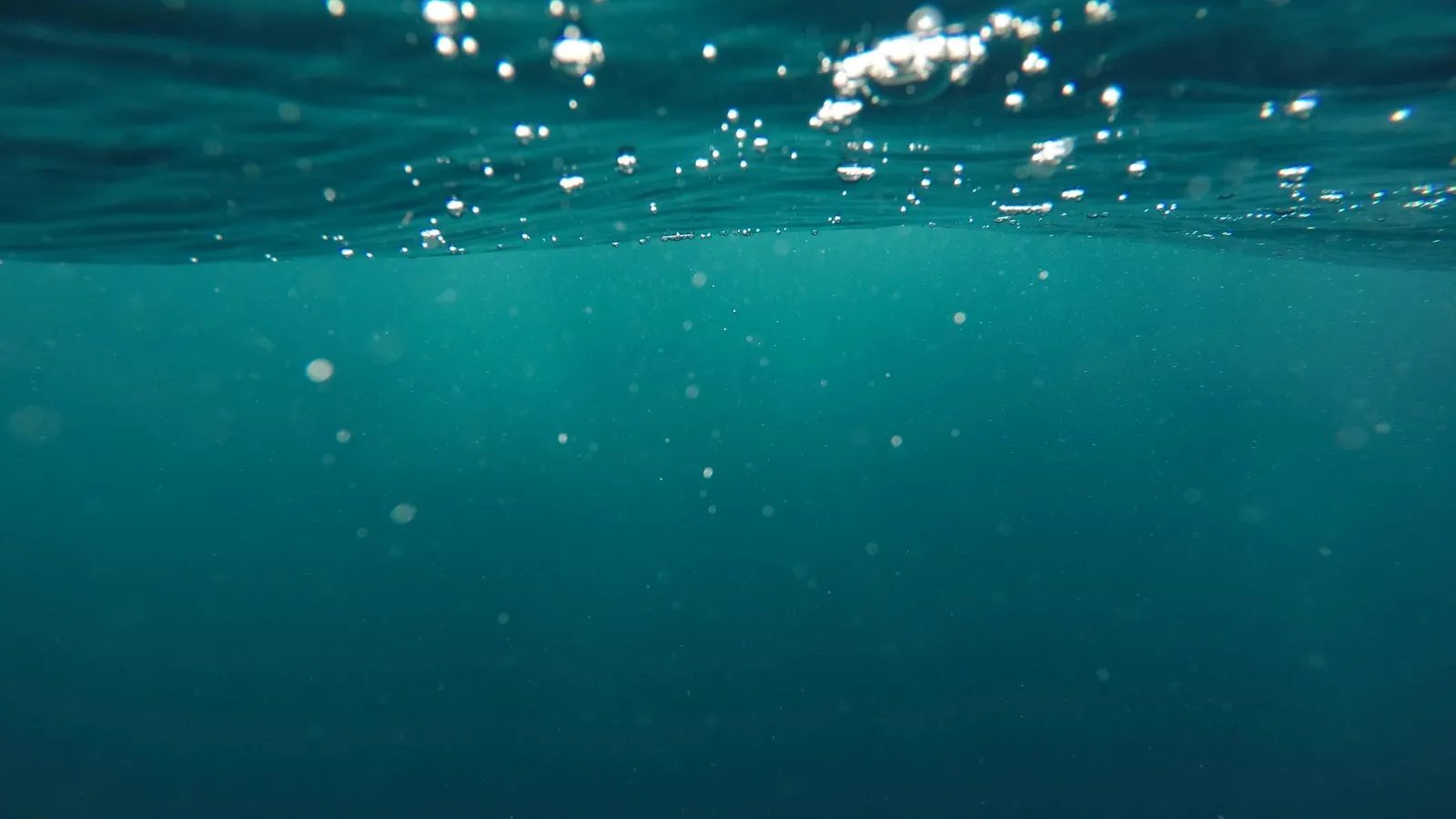 Bubbles rising through deep blue-green water