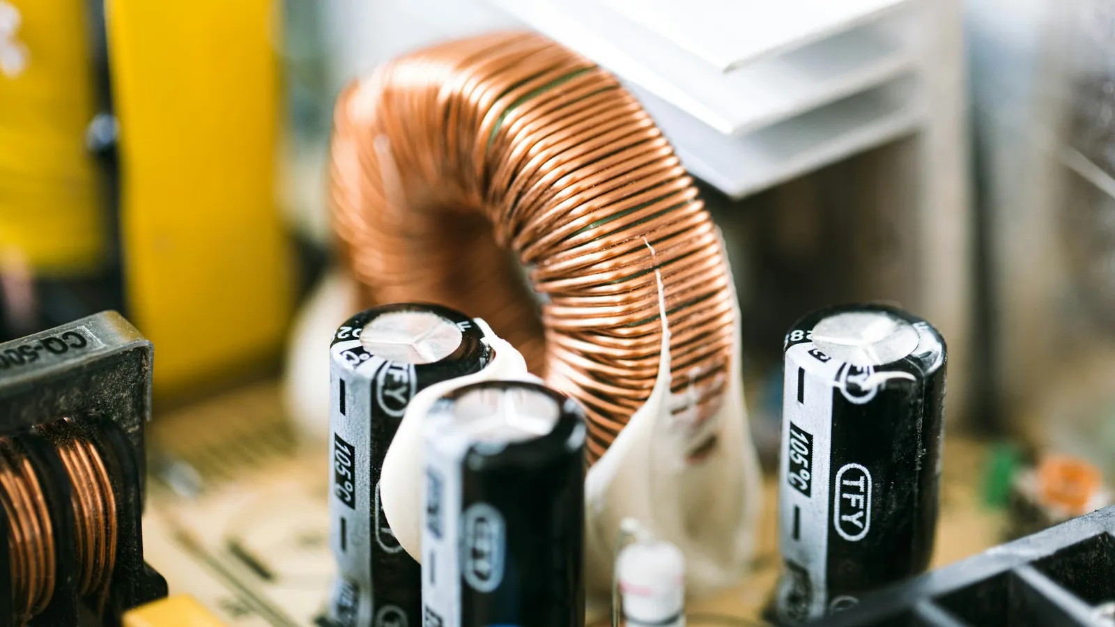Capacitors and a copper coil on a circuit board