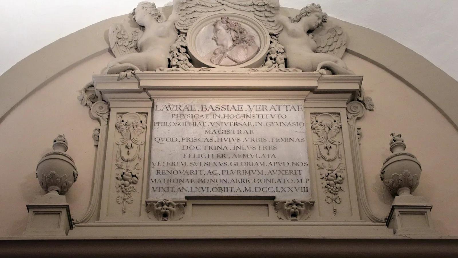 Carved stone monument to Laura Bassi with her portrait medallion and Latin inscription