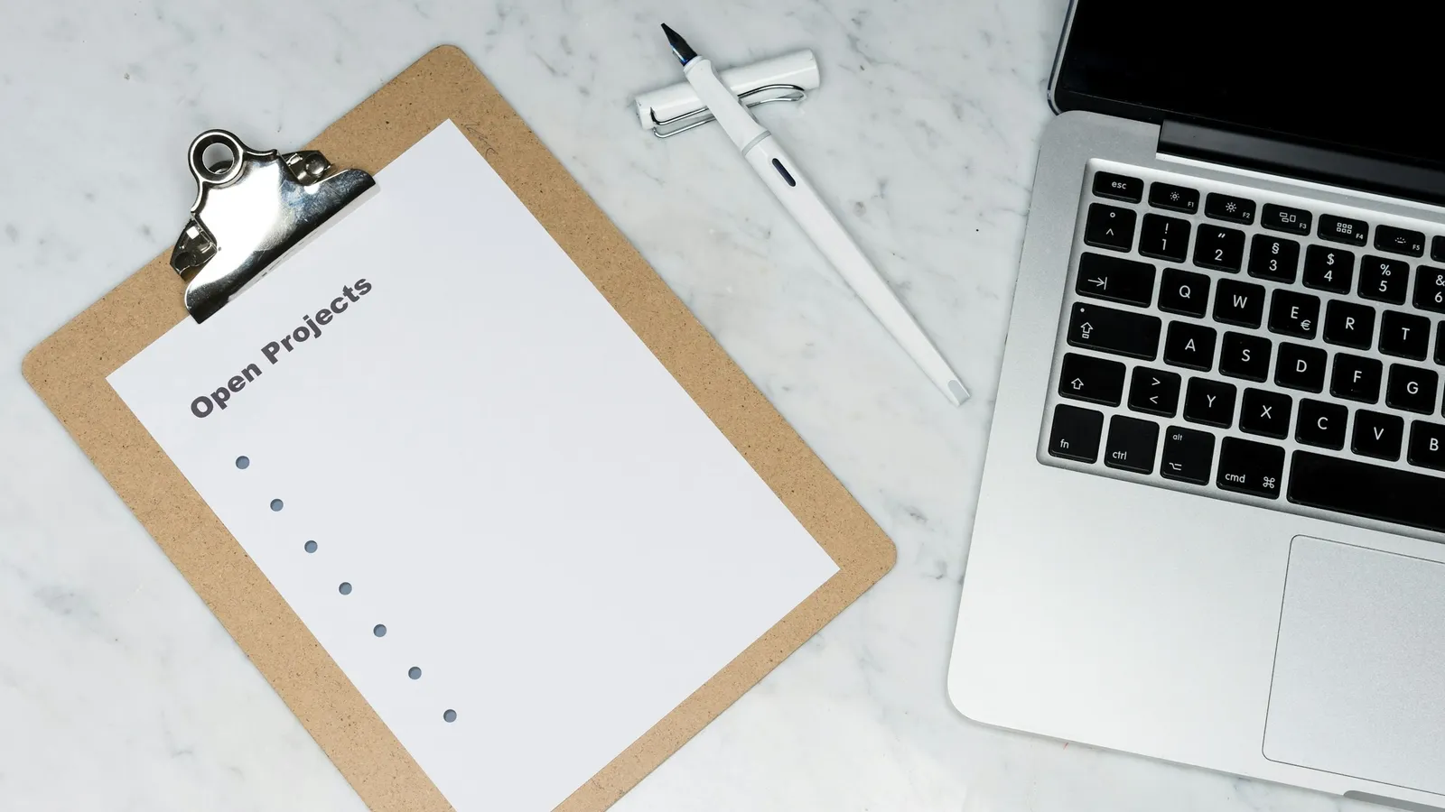 Checklist on a clipboard next to a laptop