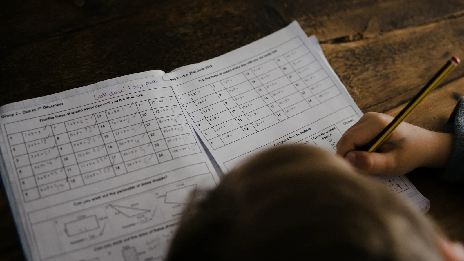 Child working through a maths workbook