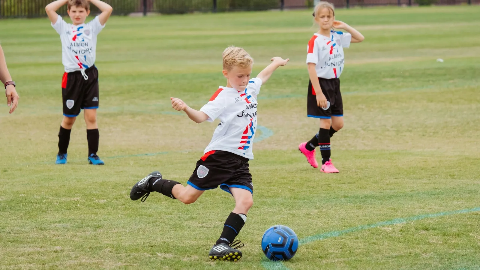 Children playing football on a grass field