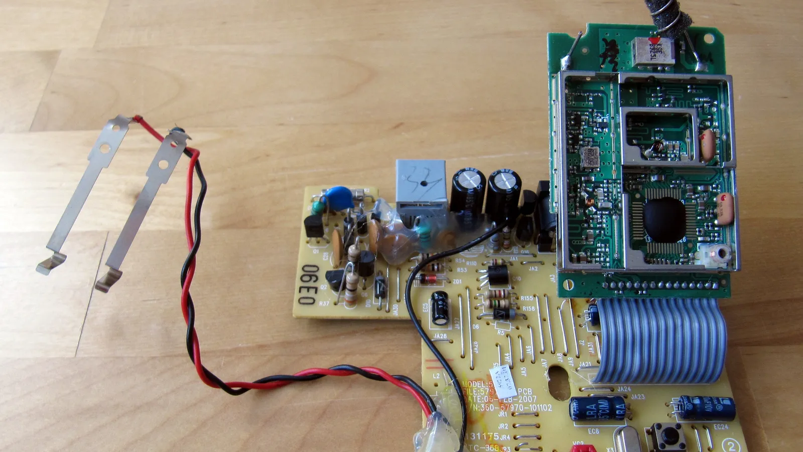 Circuit boards from an opened cordless phone base on a wooden table
