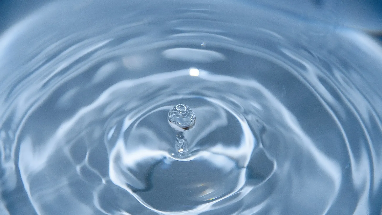 Circular ripples spreading across clear water