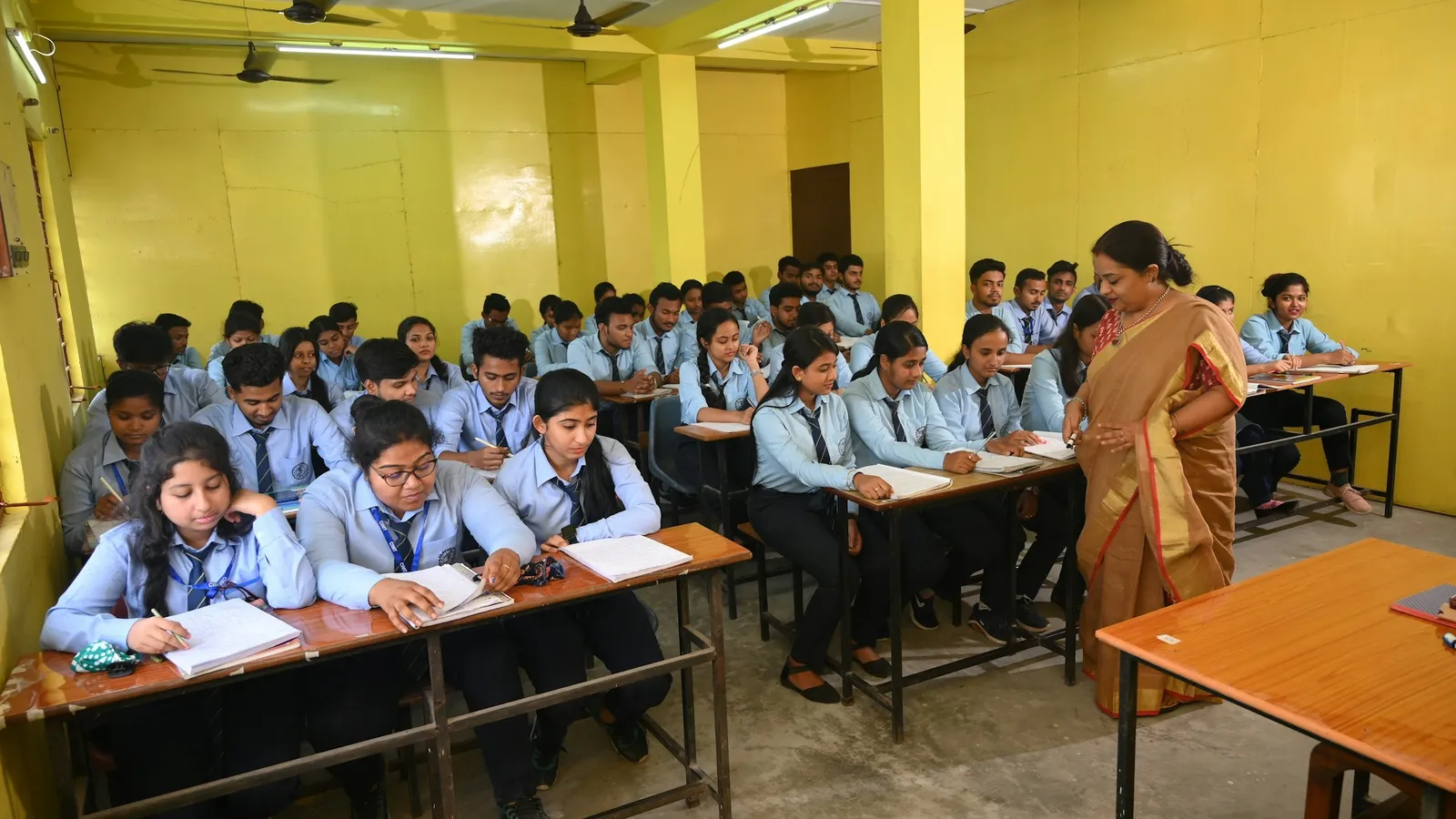 Classroom full of students in uniform with a teacher