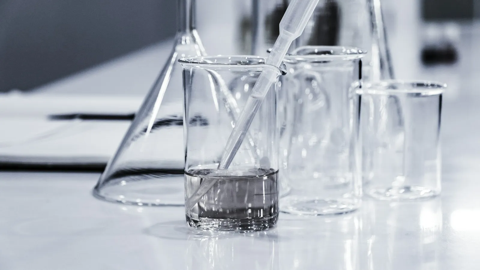 Clean glass flasks on a white lab bench