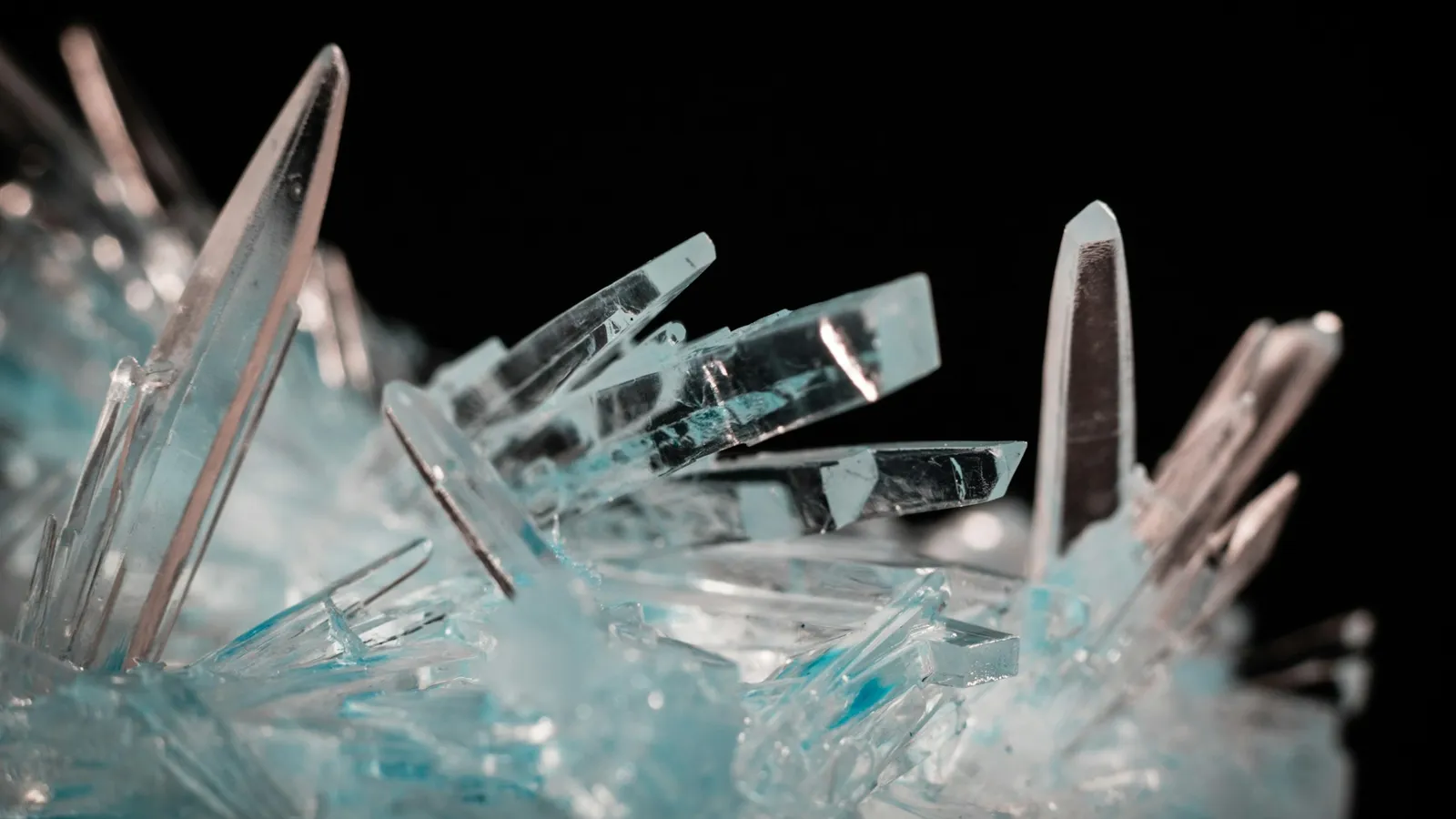 Clear needle-like crystals against a black background