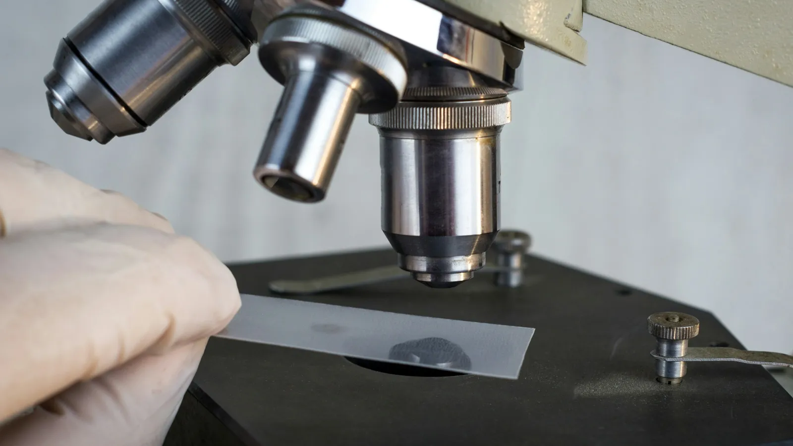 Close-up of a microscope examining a sample in a lab