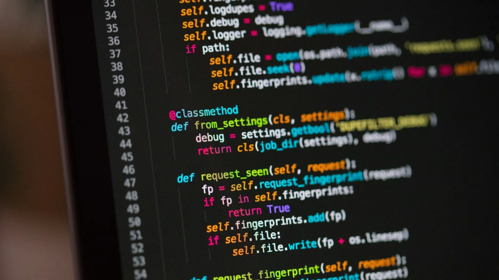 Close-up of colourful program code on a dark screen