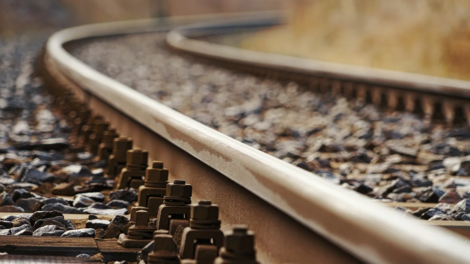 Close-up of steel railway rails curving into the distance