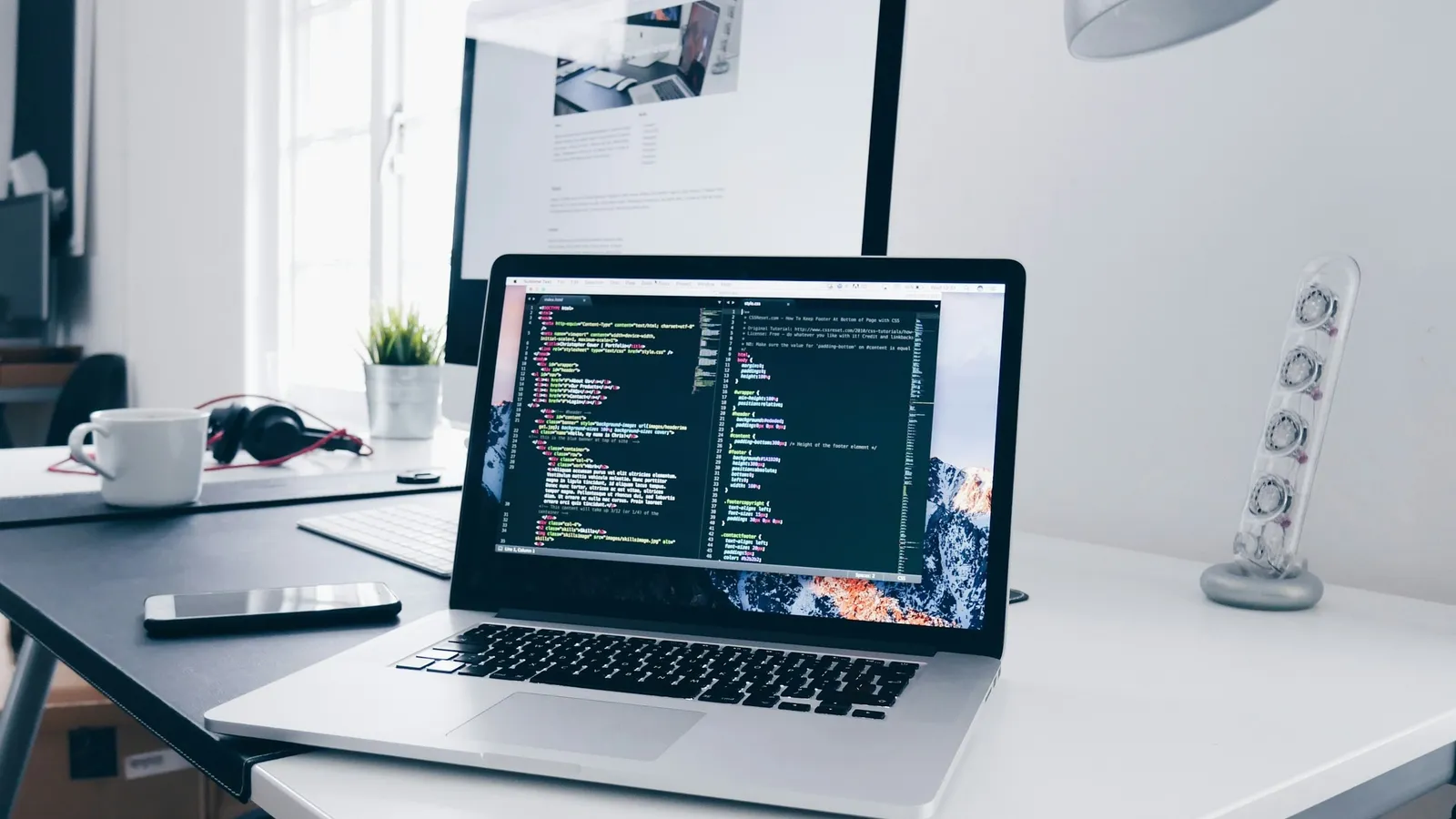 Code on a laptop screen on a white desk