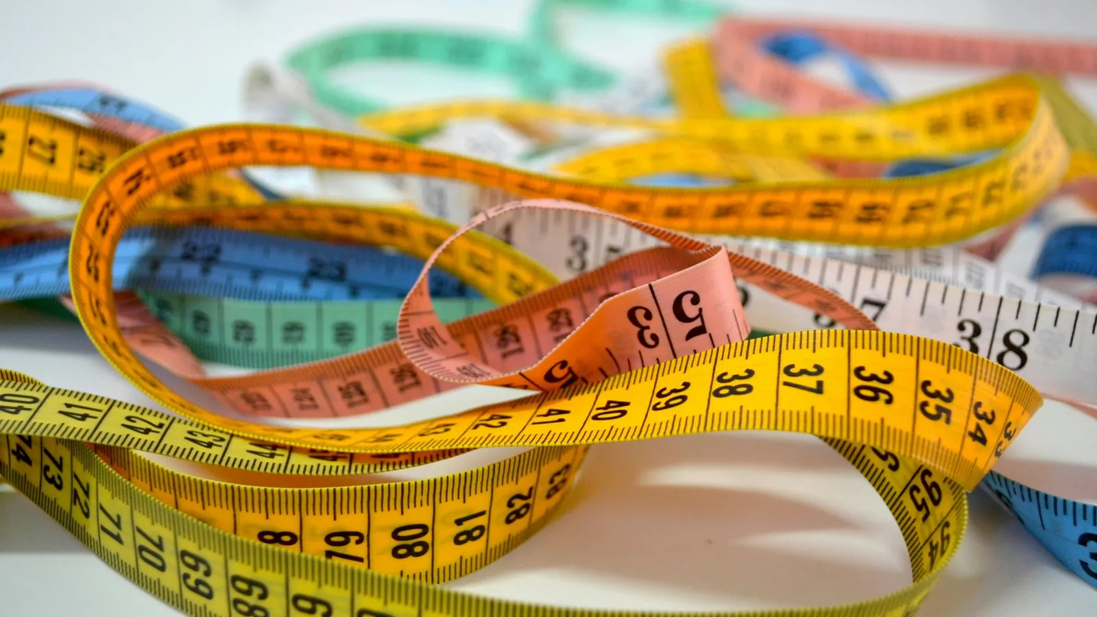 Coiled measuring tapes in bright colours