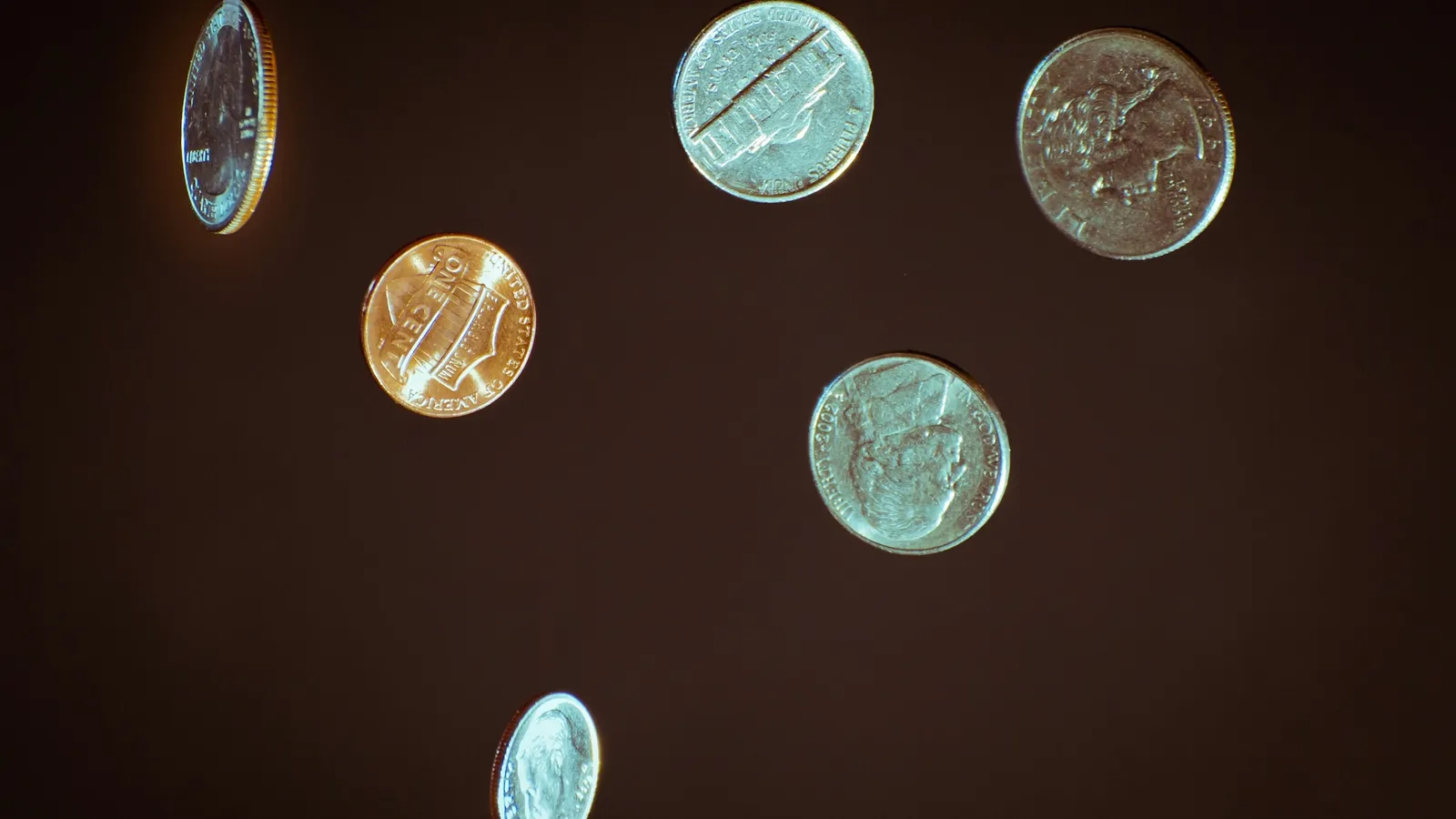 Coins scattered on a dark surface