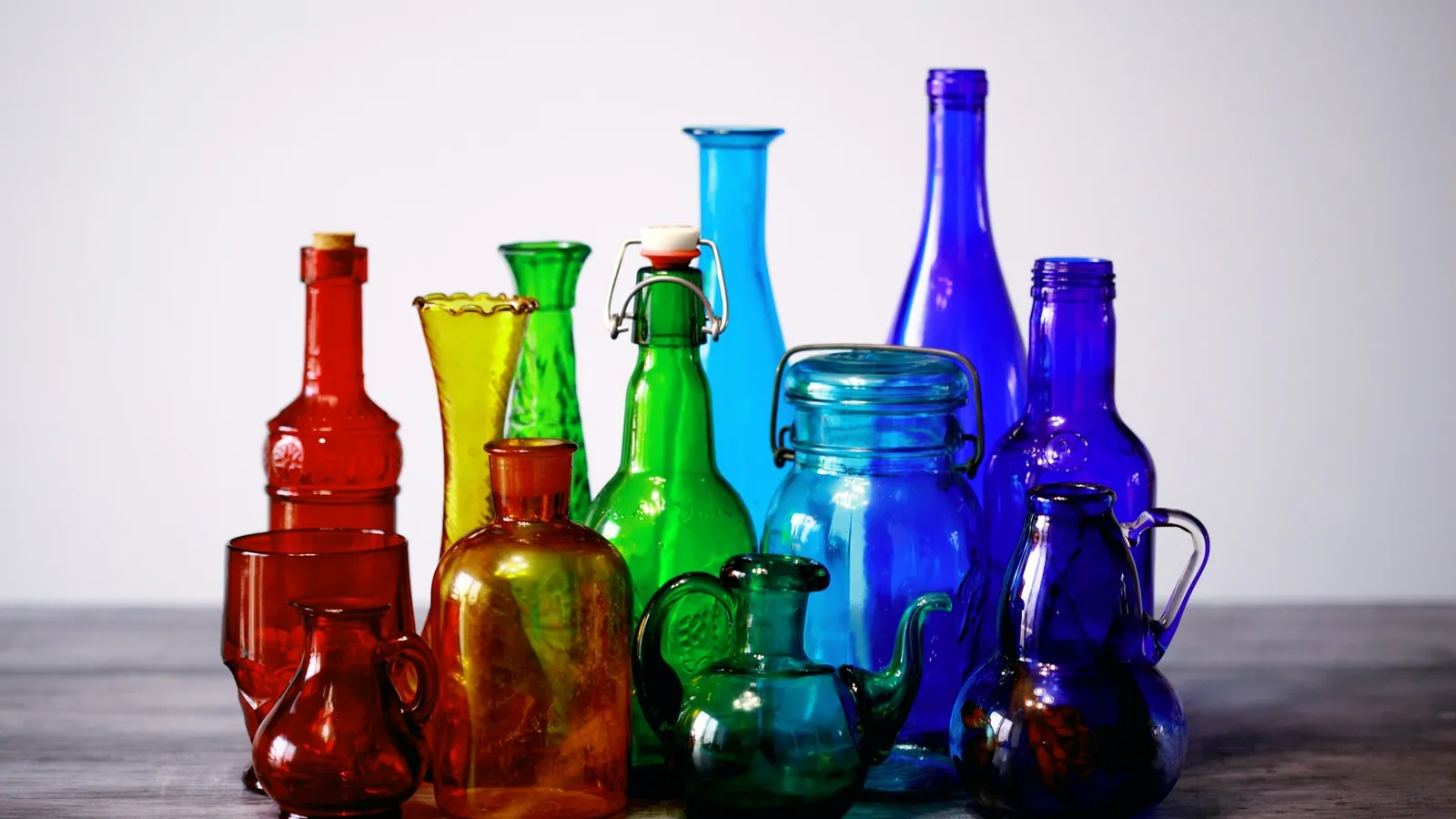 Coloured glass bottles lined up on a table