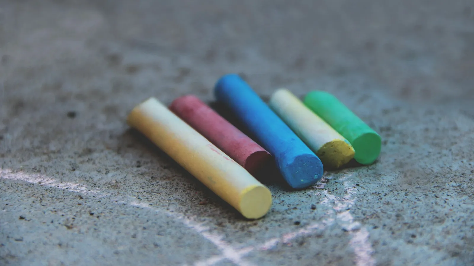 Coloured sticks of chalk lying on a grey surface