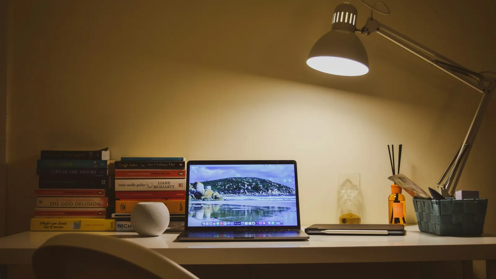Desk lamp lighting a study desk with a laptop at night