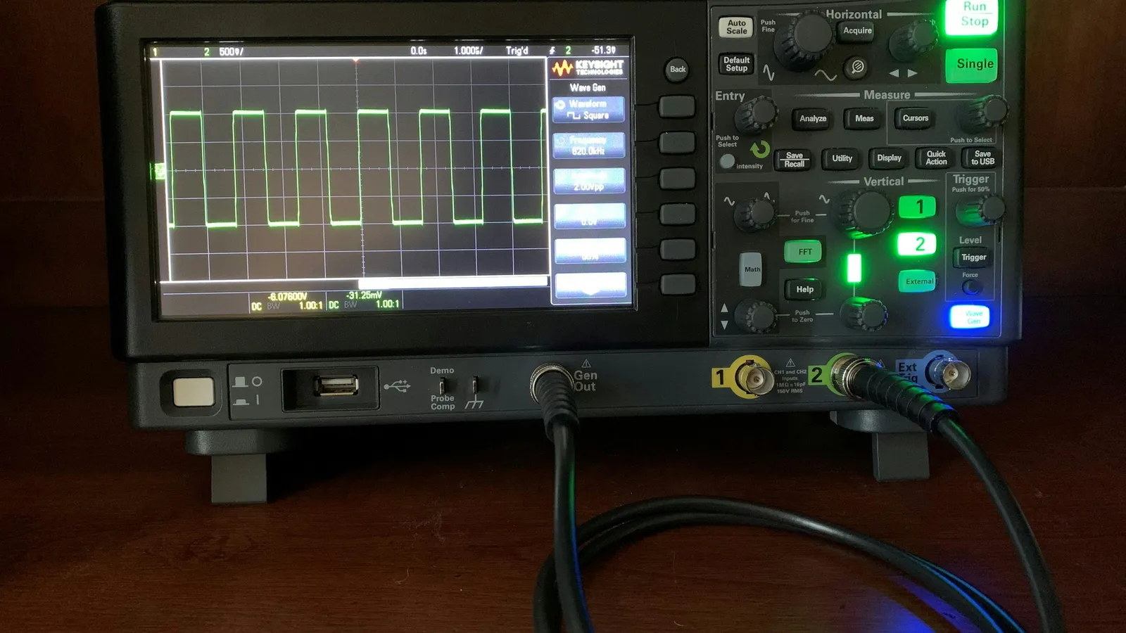 Digital oscilloscope showing electrical waveforms on its screen