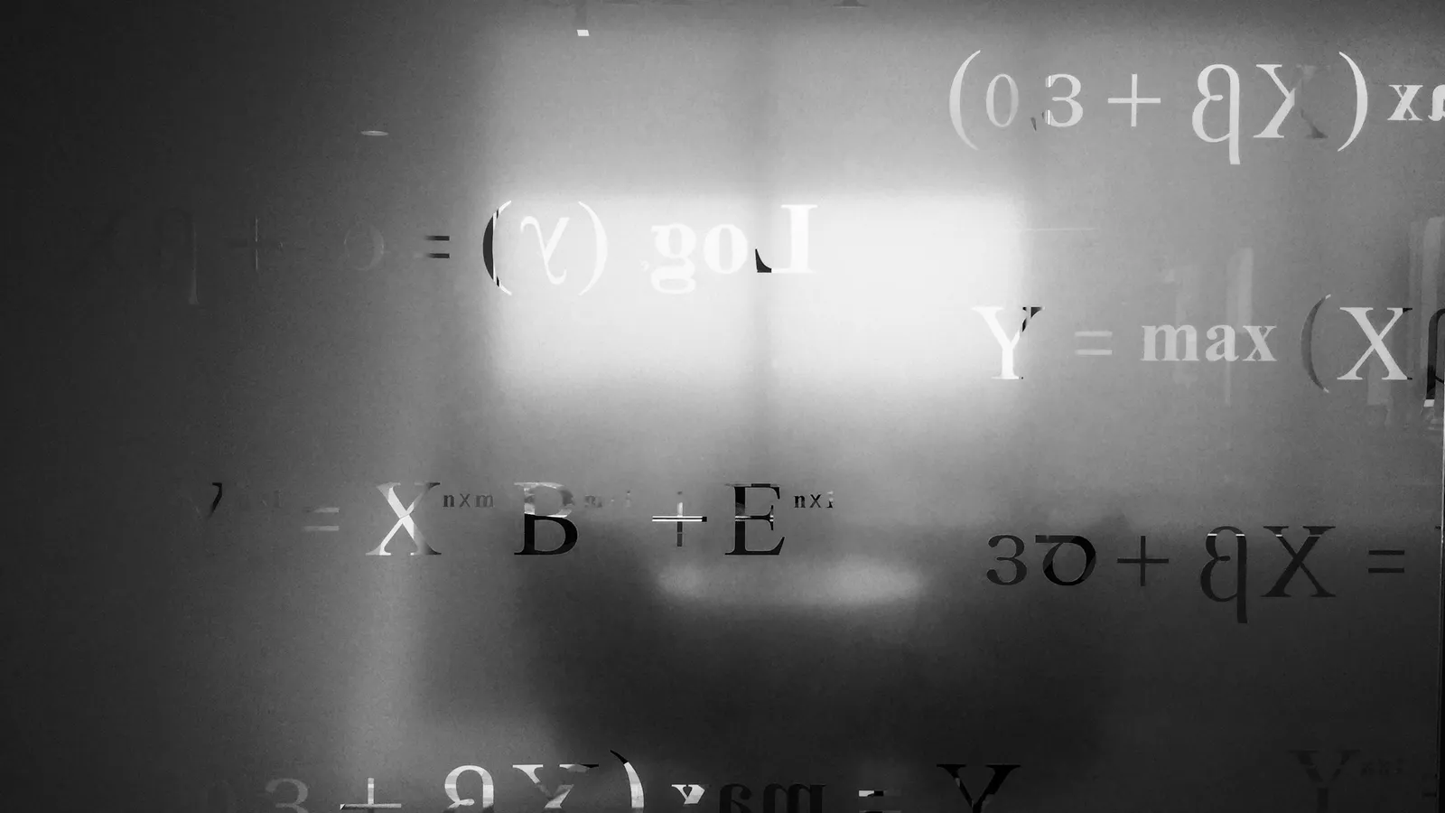 Faint physics equations written on a dark board
