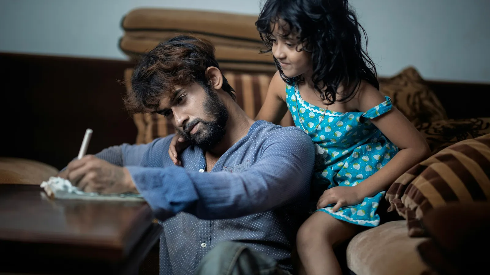 Father and daughter sitting together on a sofa
