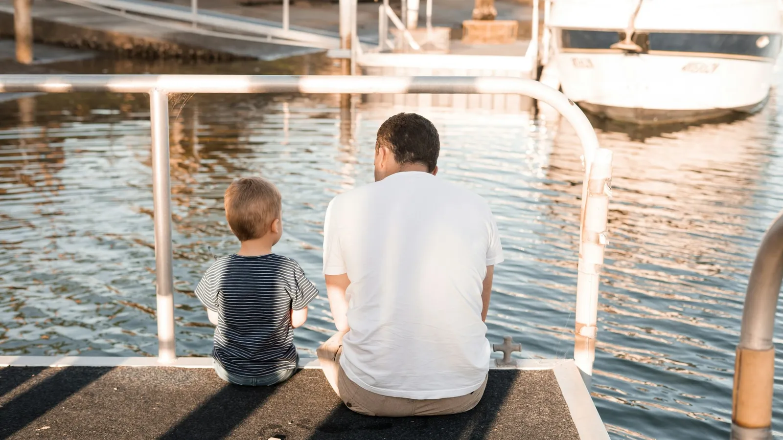 Father and son sitting together by the water