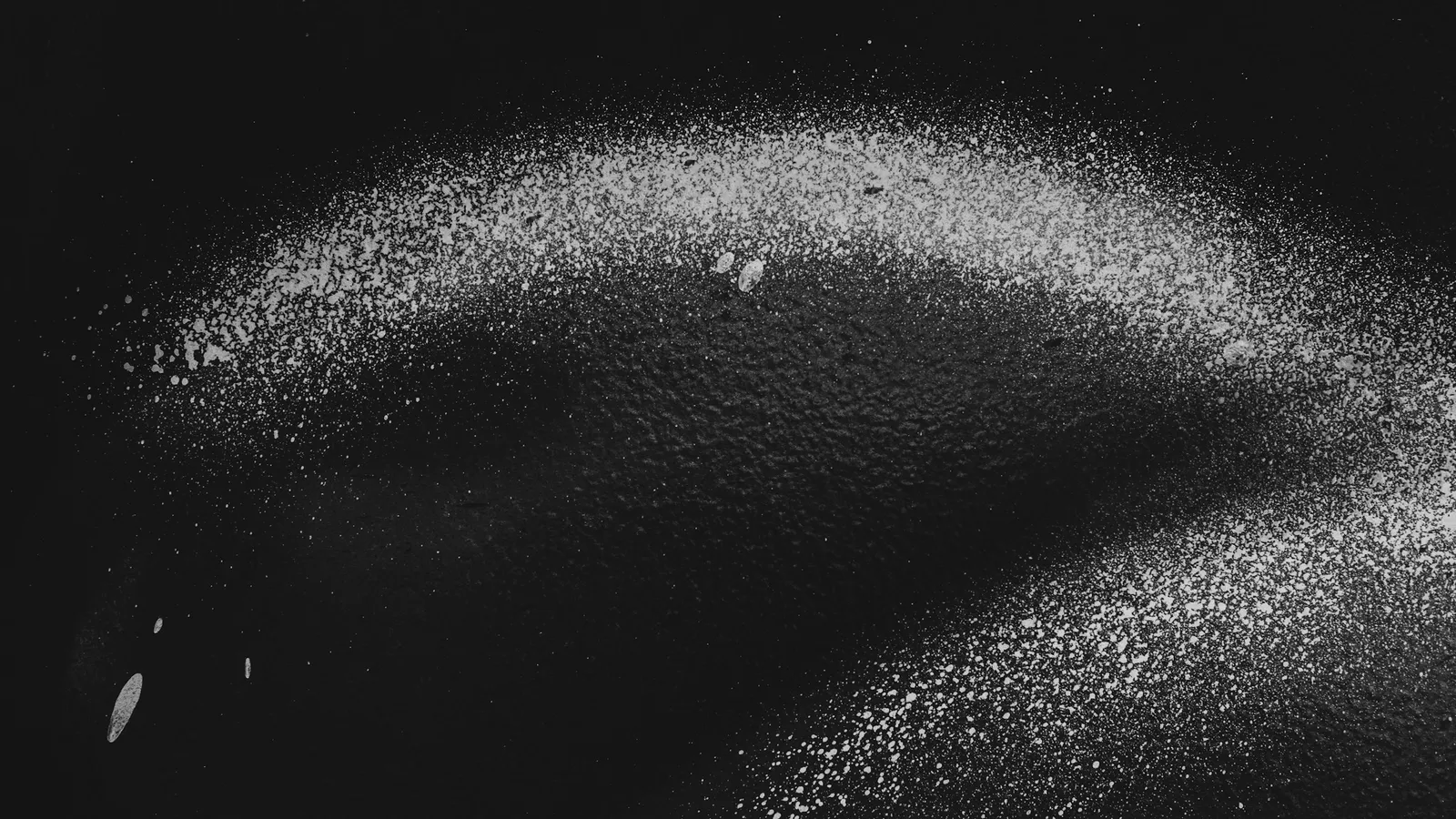 Fine grey metal powder on a black surface