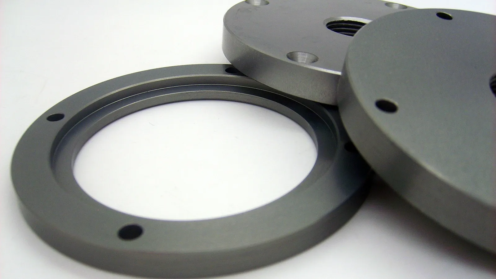 Flat metal rings and a disc on a white surface