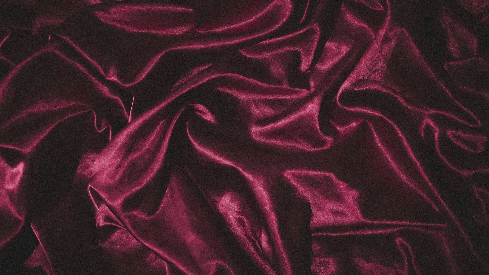 Folds of soft dark red velvet fabric