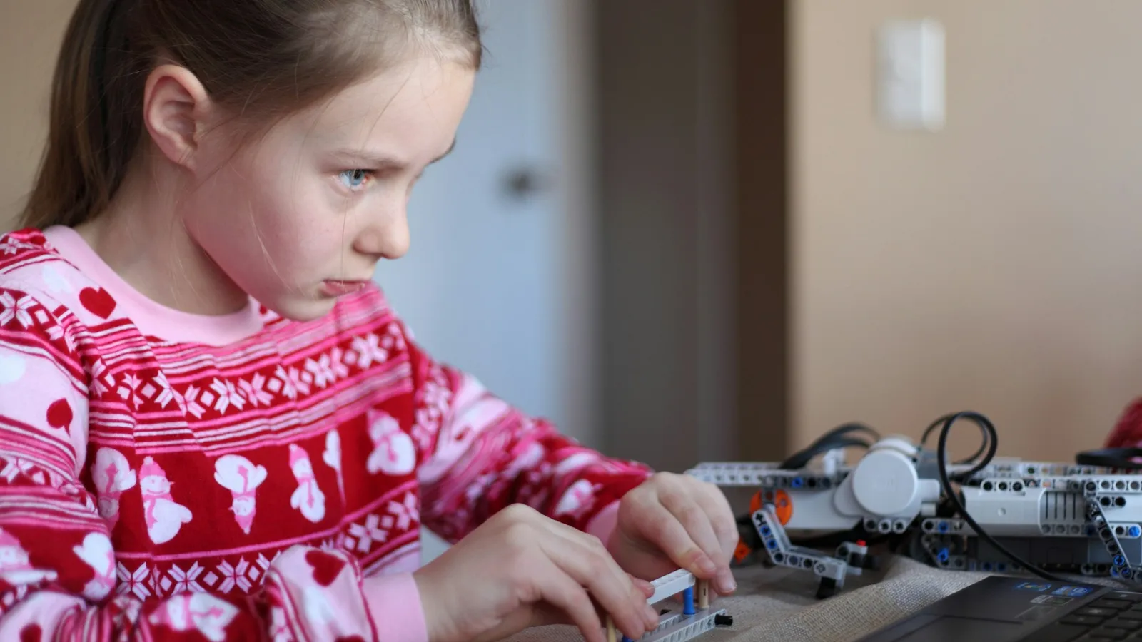 Girl building a small robot from a kit