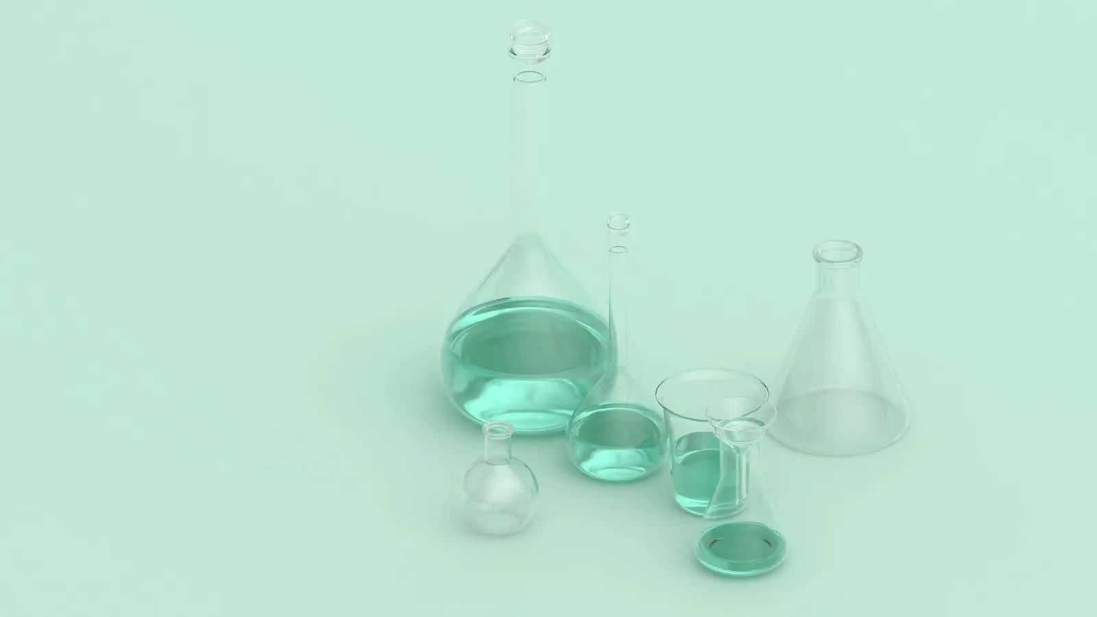 Glass flasks and beakers on a pale green background