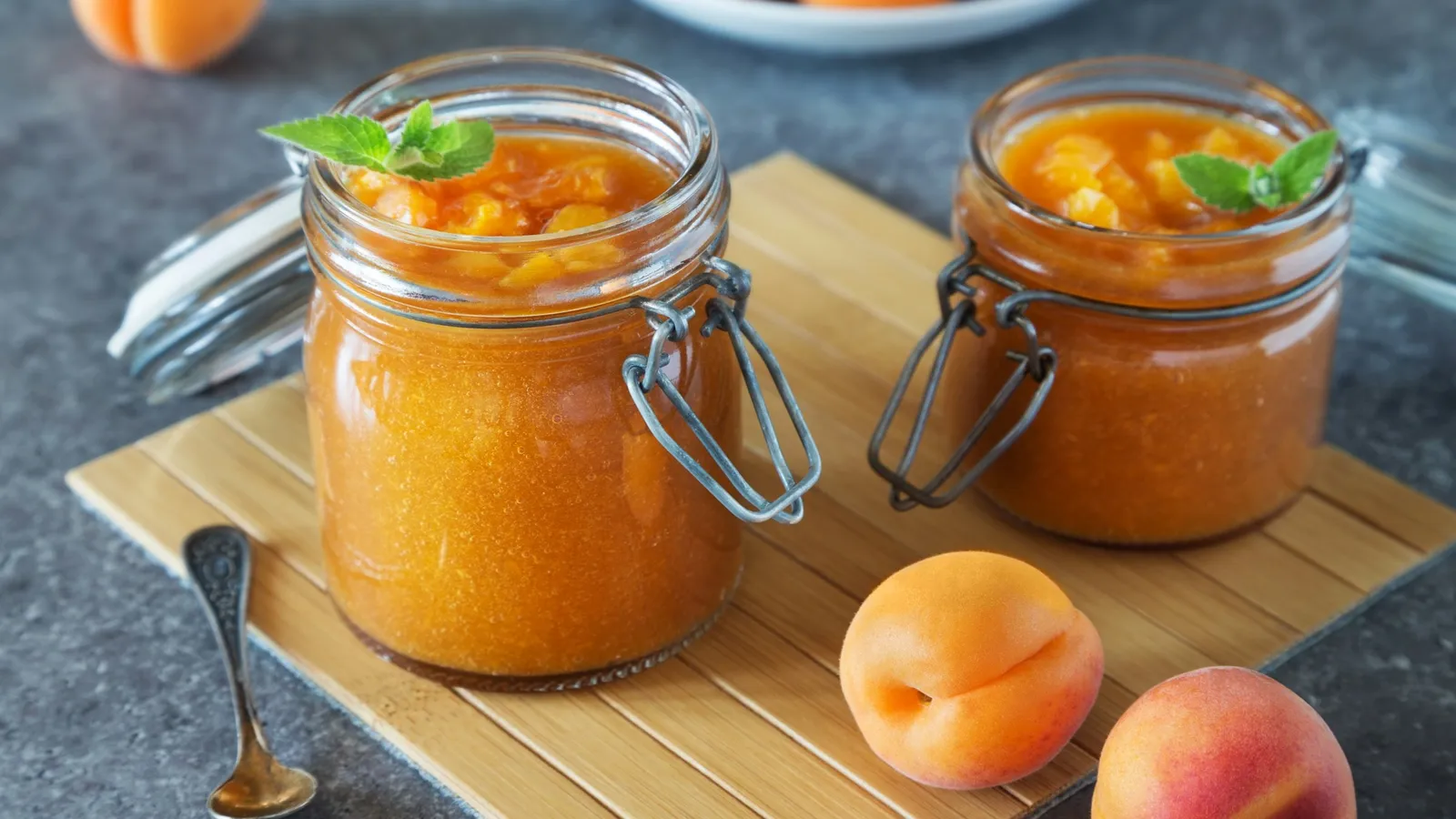 Glass jars of fruit jelly on a wooden table