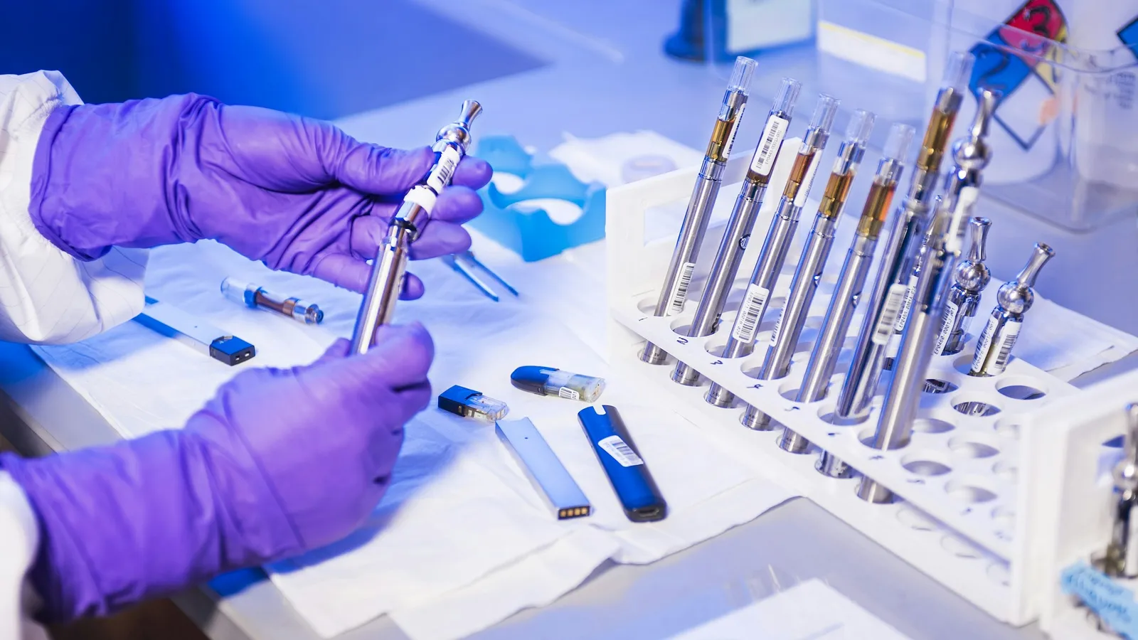 Gloved hands sorting sample tubes in a lab