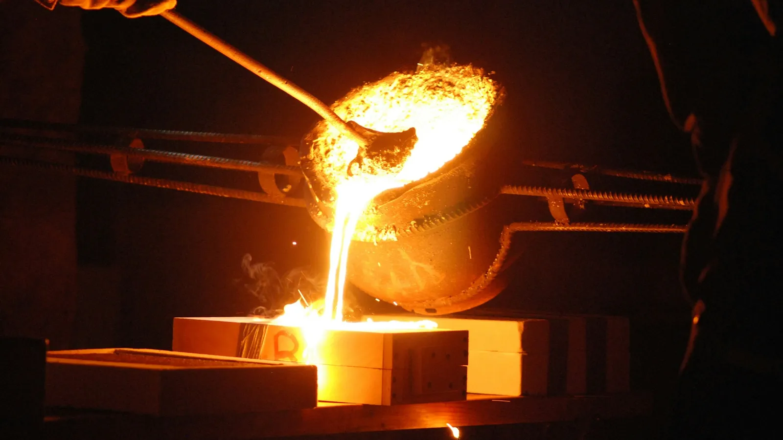 Glowing molten metal being poured in a foundry