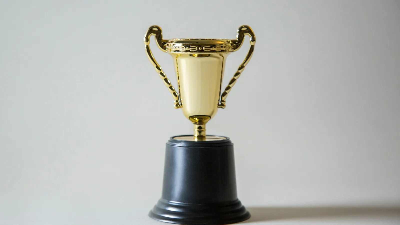 Gold trophy on a plain background