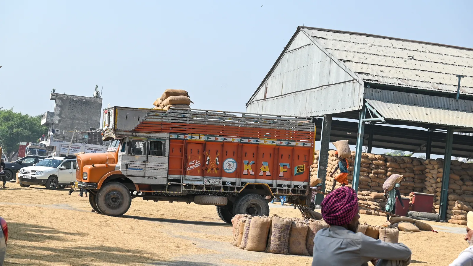 Grain sacks loaded onto a truck at an Indian grain market shed