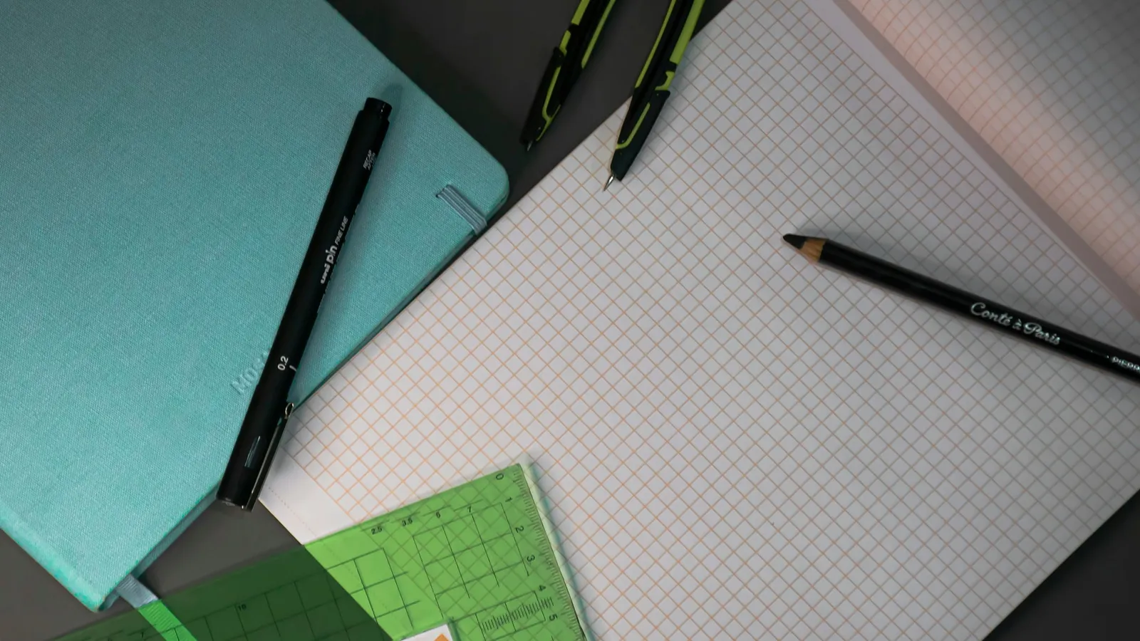 Graph paper and pens on a desk