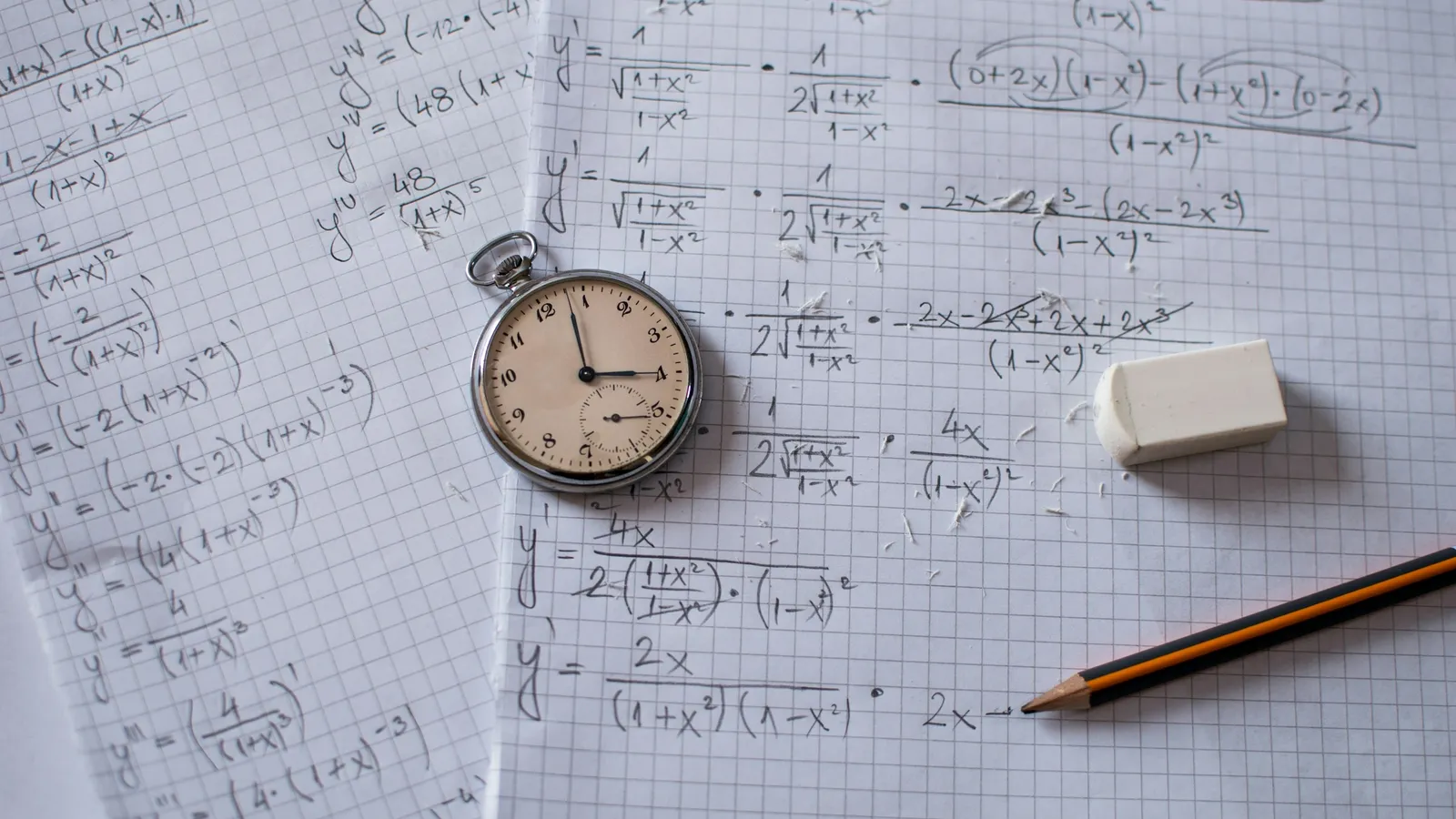 Graph paper with handwritten working, a stopwatch and a pencil