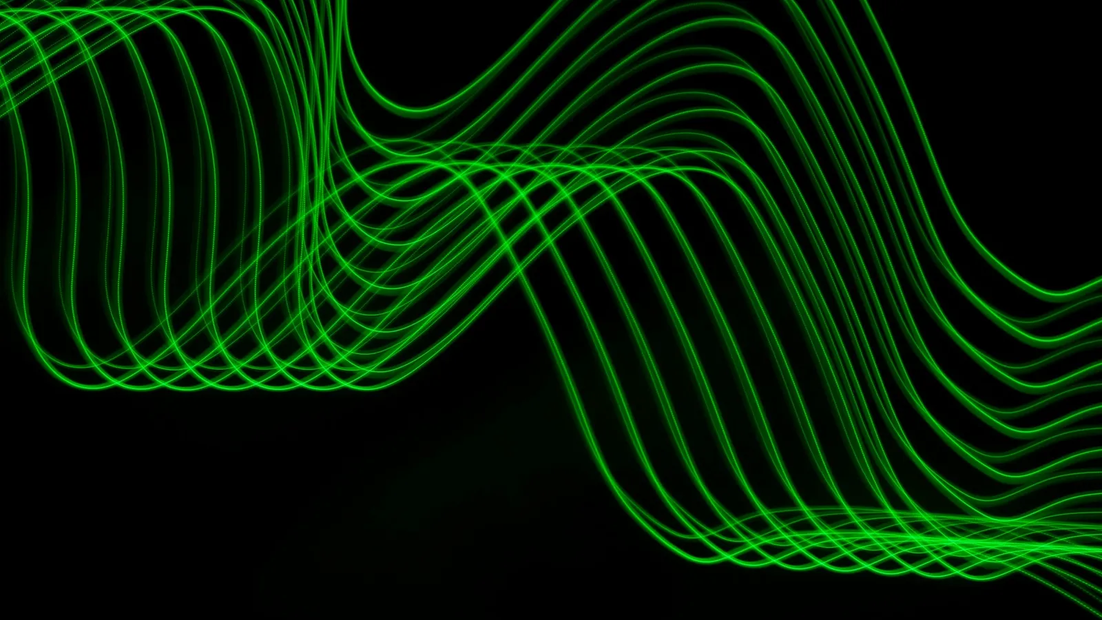 Green light waves curving across a dark background
