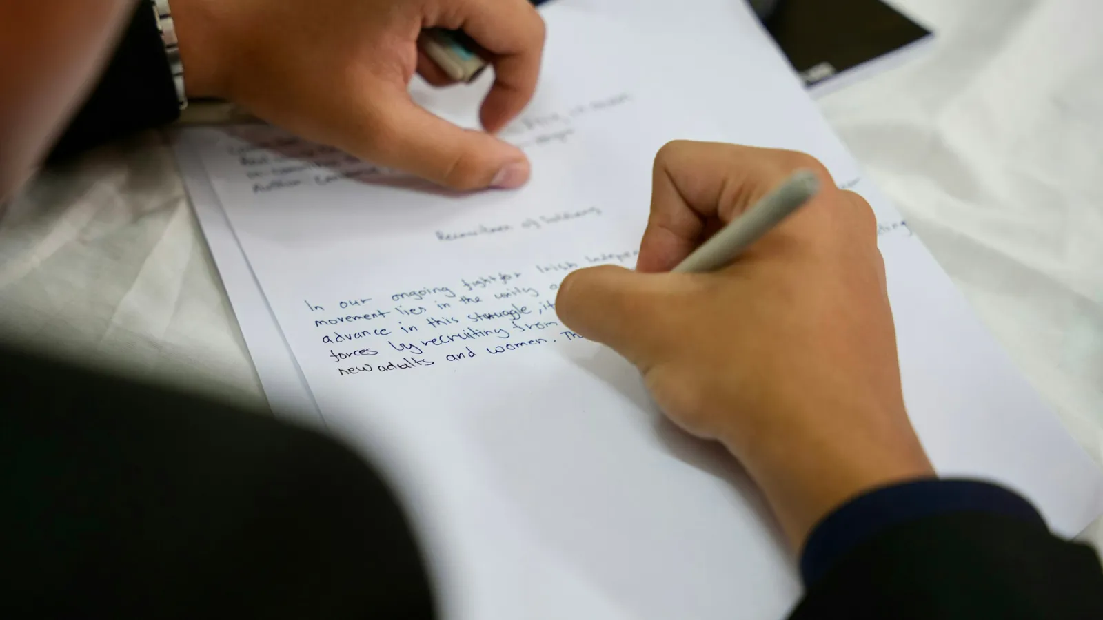 Hand writing a summary on paper