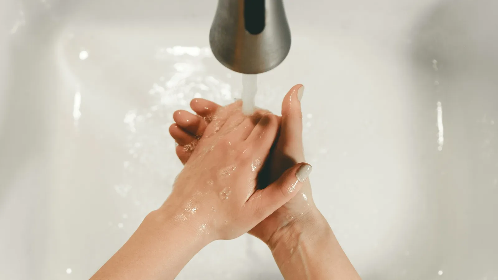 Hands being washed under a running tap